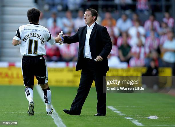 Derby County manager Billy Davies gives water to Paul Peschisolido during the Coca-Cola Championship match between Derby County and Sunderland at...