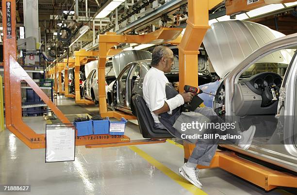 Chrysler Group assembly line worker Earl Gasaway sits in an ERGO seat while installing center consoles on a new 2007 Chrysler Sebring Sedan at the...
