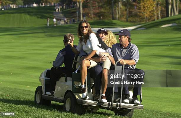 Tom Lehman and his wife Melissa along with Paul Azinger of USA ride off in a golf cart during the President's Cup at The Robert Trent Jones Golf Club...