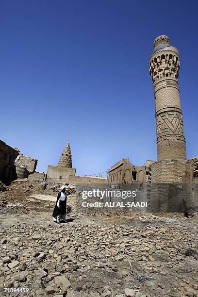 An Iraqi Shiite cleric looks at the 750-year-old minaret of the Nakhila mosque in Kafel, northeast of the holy Shiite city of Najaf, in central Iraq,...