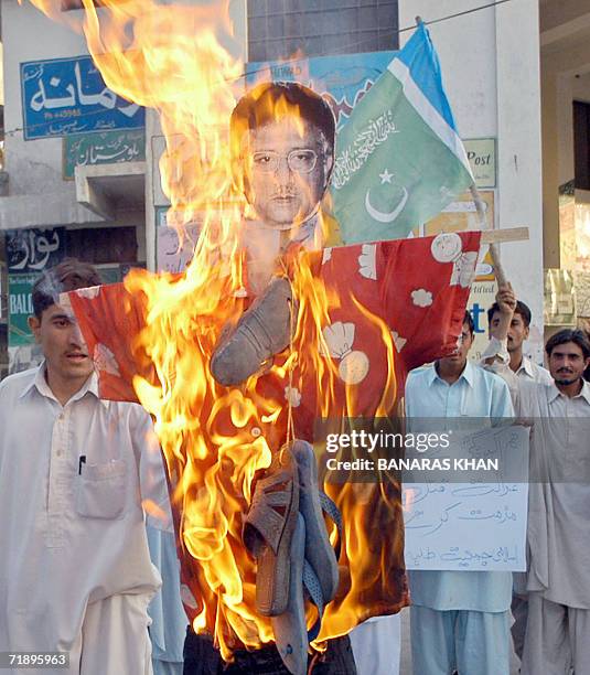 Pakistani activists from Jamaat-e-Islami torch an effigy of President Pervez Musharraf, during a protest against the killing of rebel tribal chief...