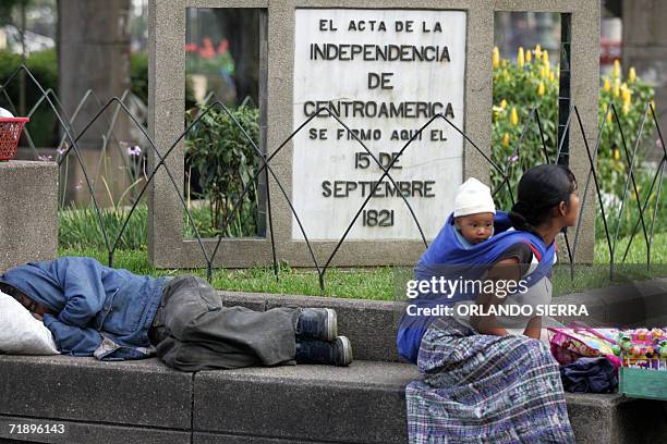 Una mujer indigena con su hijo en la espalda observa los desfiles desde la esquina donde se firmo el acta de independencia de Centroamerica en 1821,...