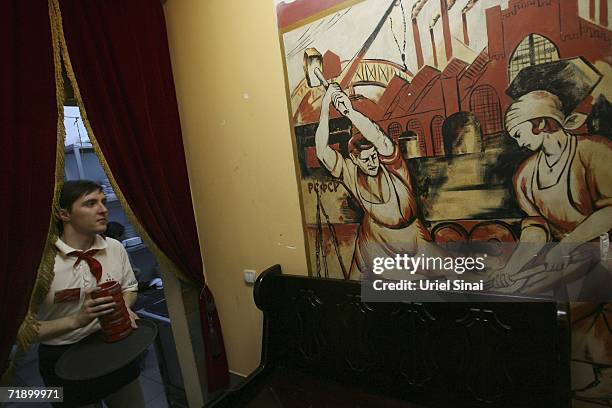 Waitress passes a workers' mural in the CCCP restaurant, which was opened three years ago and decorated with Soviet and Communist symbols, August 9,...