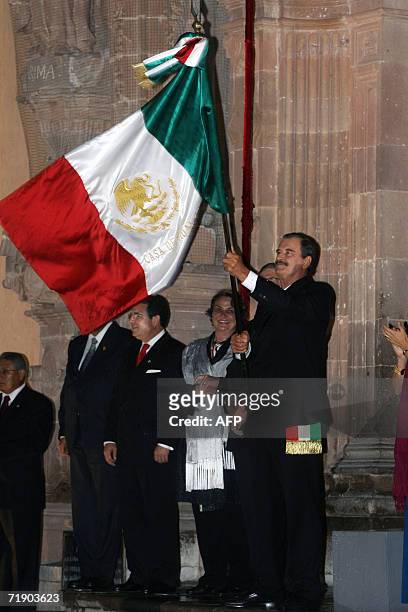 Mexican President Vicente Fox waves the national flag in Dolores Hidalgo Community in Guanajuato State during celebrations of Mexico's Independence...