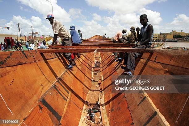 Emigration clandestine: les bonnes affaires d'un fabricant de pirogue" Workers build a pirogue at the port of Saint-Louis 14 September 2006. Since...