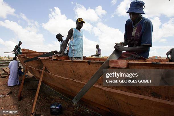 Emigration clandestine: les bonnes affaires d'un fabricant de pirogue" Workers build a pirogue at the port of Saint-Louis 14 September 2006. Since...