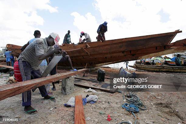 Workers build a pirogue at the port of Saint-Louis 14 September 2006. Since the begining of the year the demand for pirogues have increased as more...