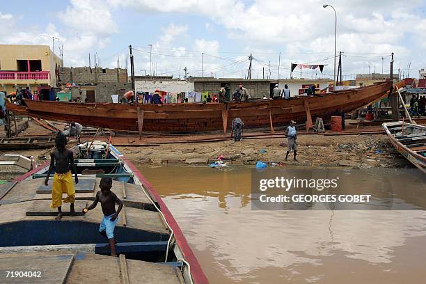 Workers build a pirogue at the port of Saint-Louis 14 September 2006. Since the begining of the year the demand for pirogues have increased as more...