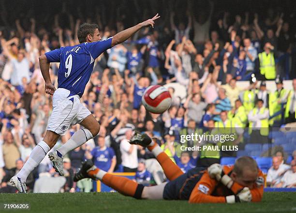 Liverpool, UNITED KINGDOM: Everton's James Beattie celebrates after socring against Wigan Athletic goalkeeper Chris Kirkland during their English...