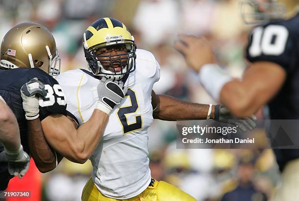 Shawn Crable of the Michigan Wolverines rushes quarterback Brady Quinn of the Notre Dame Fighting Irish as he is blocked by John Carlson of Notre...
