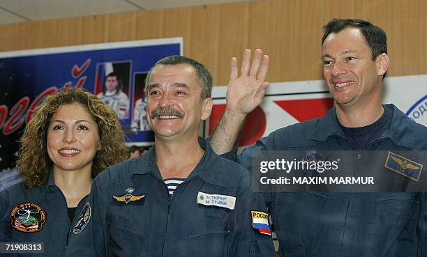 Astronaut Michael Lopez-Alegria , Russian cosmonaut Mikhail Tyurin and the world's first female space tourist Anoushen Ansari smile while they pose...