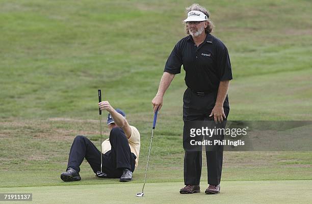 Stewart Ginn of Australia and Tony Johnstone of Zimbabwe line up their putts on the 18th hole during the final round of the Midas Group English...