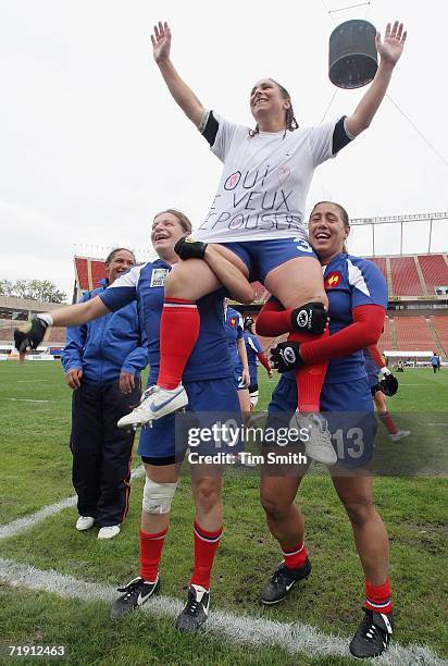 Fanny Gelis of France displays her shirt proclaiming that she accepts a marriage proposal from her boyfriend in the stands while being hoisted by...