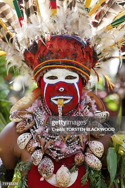 Goroka, PAPUA NEW GUINEA: A Kukulka Amps woman from Mt Hagen blows a whistle while performing in the 50th Goroka singsing in what is believed to be...