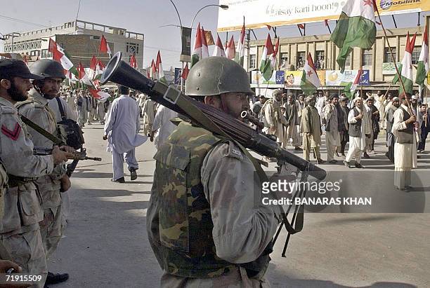 Pakistani paramilitary soldiers watch as protesters gather for a public rally in Quetta, 18 September 2006. The public meeting was organized by...