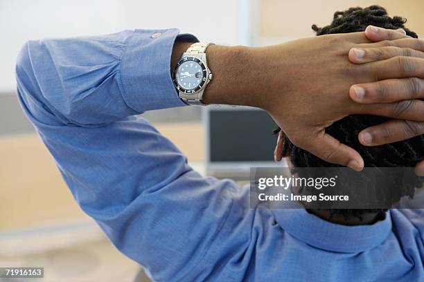 man with hand on head - stretching hands behind head rear view stock-fotos und bilder