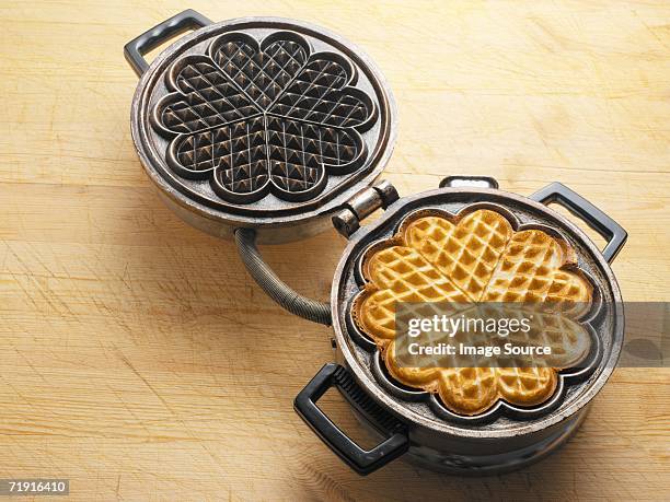 waffle in a waffle iron - waffeln stock-fotos und bilder