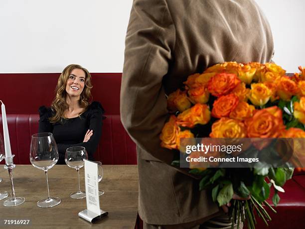 man arriving at restaurant with bunch of roses - bridge building glass stock pictures, royalty-free photos & images