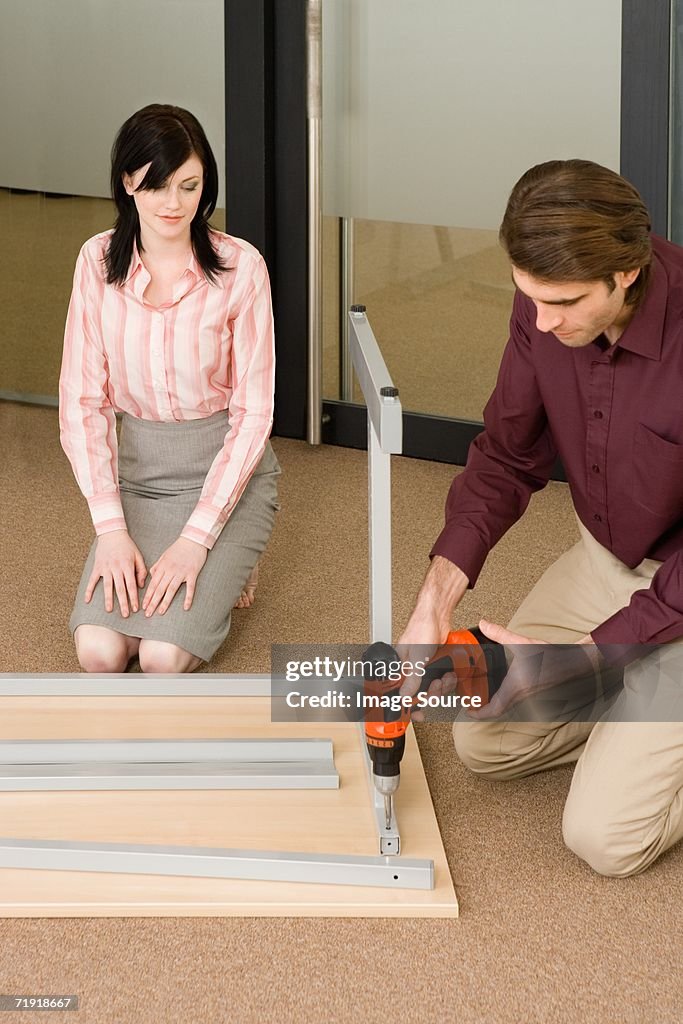 Homem a configuração de tabela, mulher assistindo