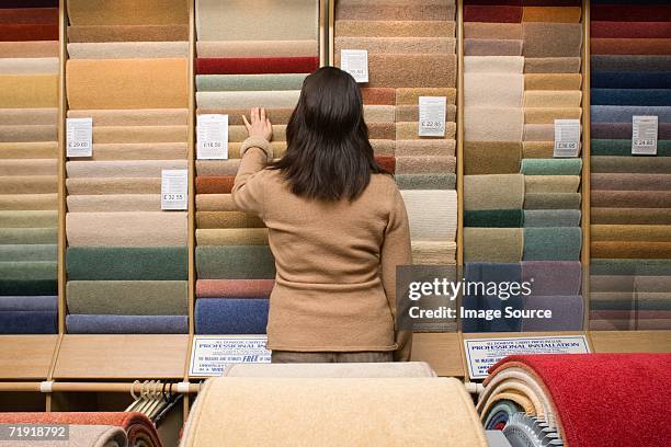 woman choosing carpet - tapijt stockfoto's en -beelden