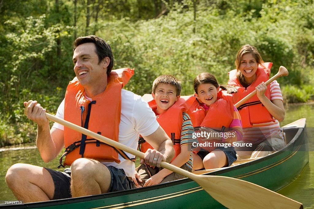 Family wearing life jacket in canoe