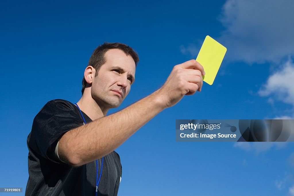 Referee holding yellow card