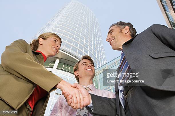 businesspeople shaking hands - three storey stock pictures, royalty-free photos & images