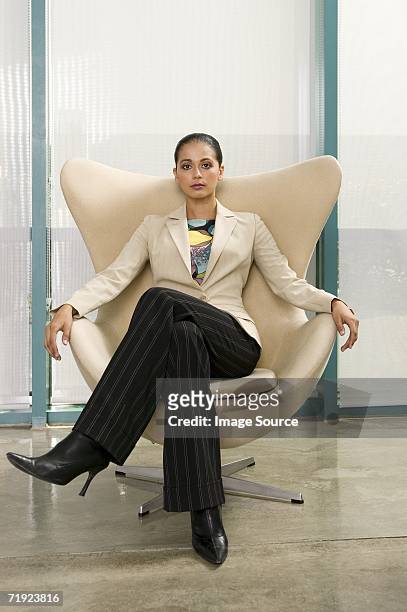businesswoman sitting in a chair - businesswoman in suit jackets stock-fotos und bilder