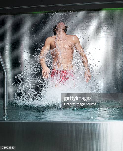 man jumping in swimming pool - auftauchen wasser stock-fotos und bilder