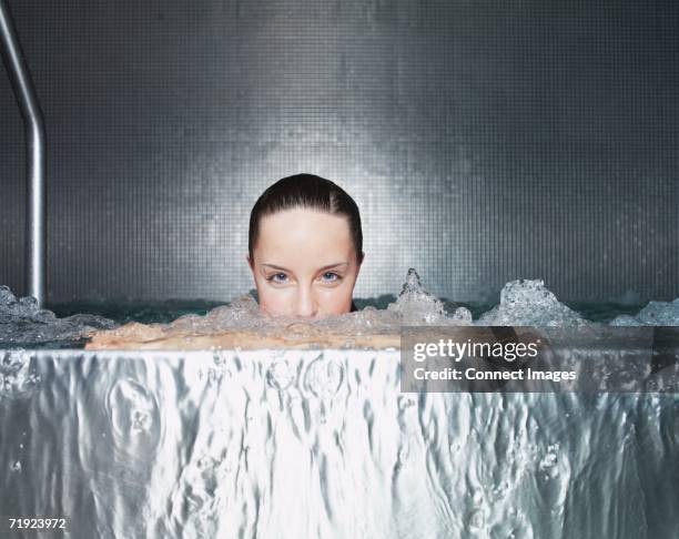 woman immersing in whirlpool - balneotherapy stock pictures, royalty-free photos & images
