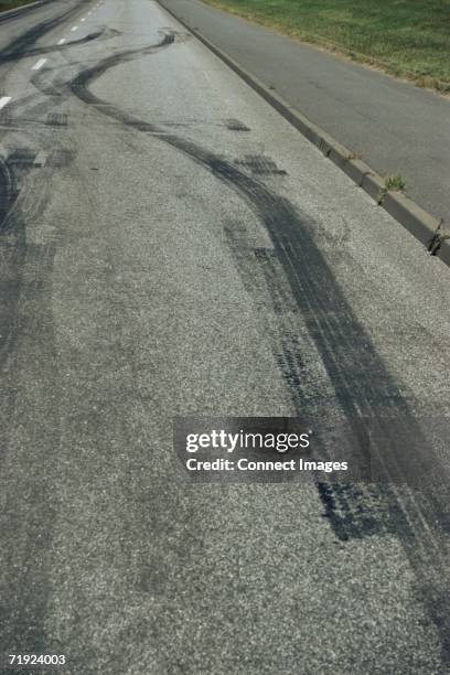 tyre tracks on a road - curb stock pictures, royalty-free photos & images