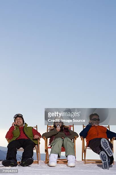 snowboarders using cell phones - après ski stockfoto's en -beelden