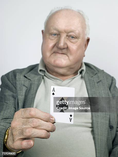 senior man holding the ace of spades - ace of spades stock pictures, royalty-free photos & images