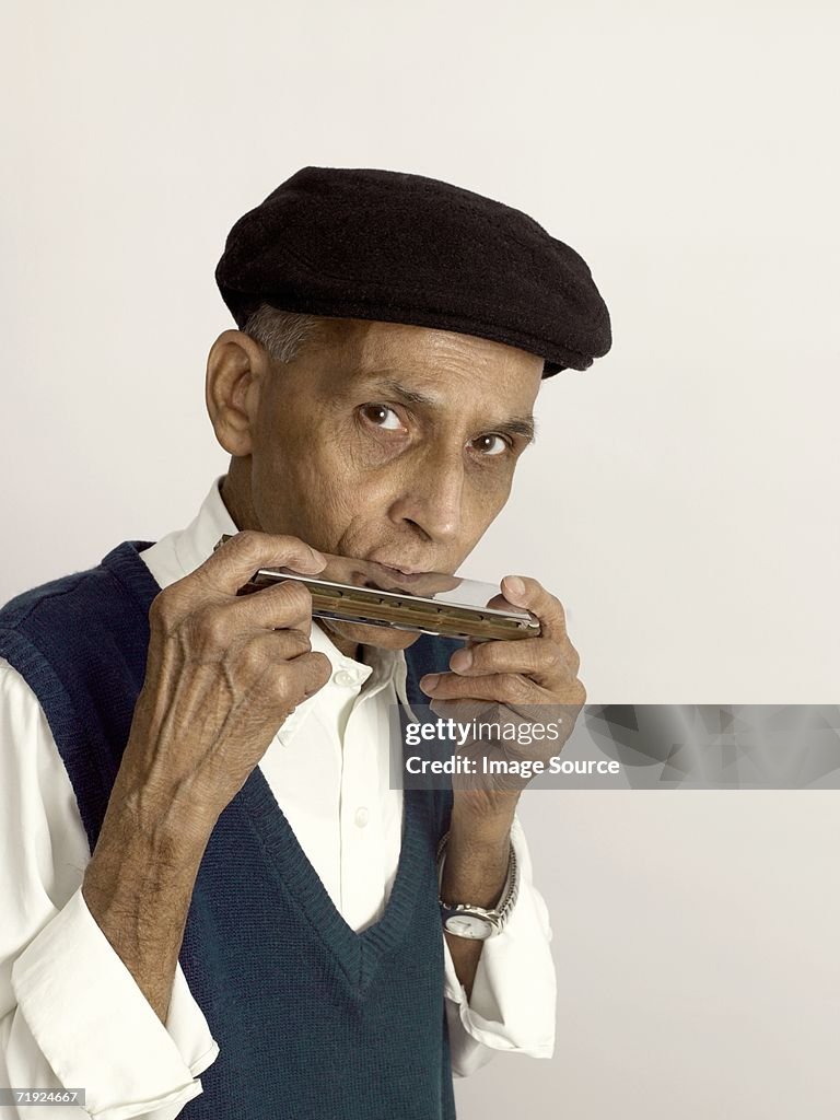 Senior man playing the harmonica