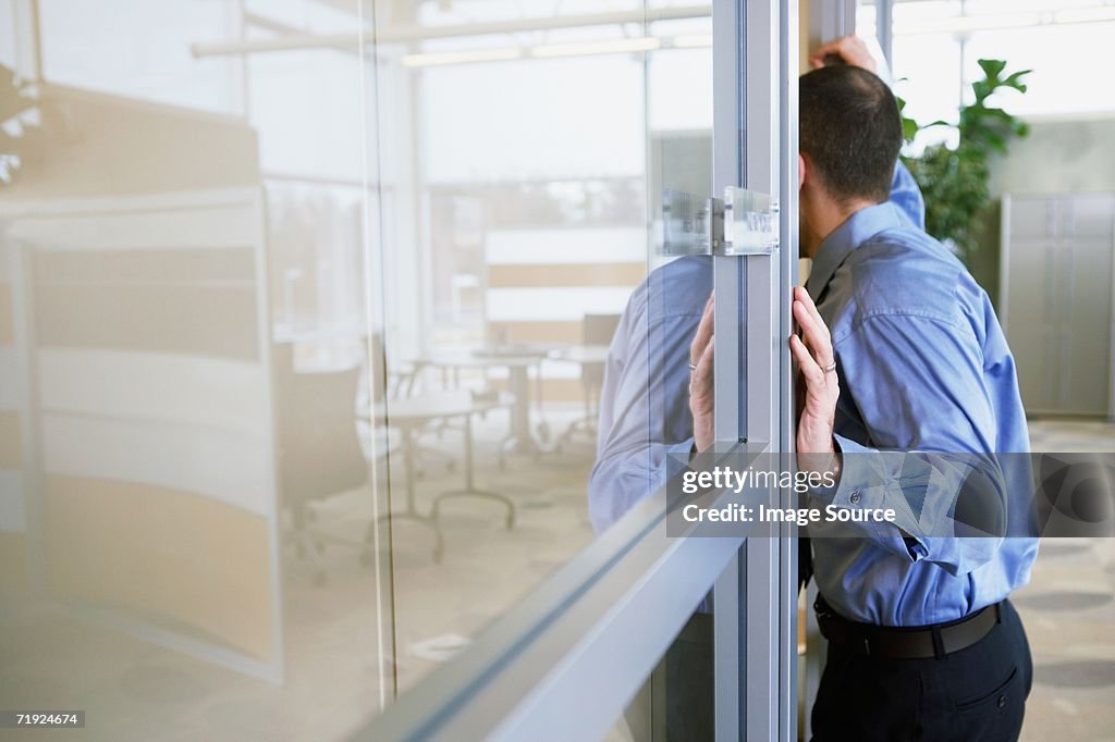 Male office worker leaning in doorway