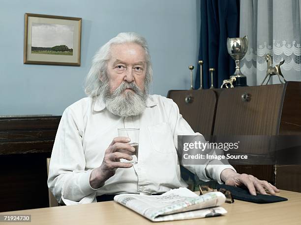 man with glass of water and newspaper - long beard stock pictures, royalty-free photos & images