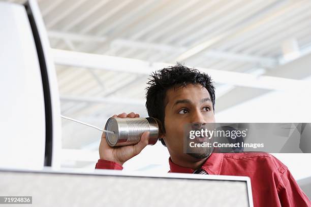 man using a tin can telephone - professional appearance stock pictures, royalty-free photos & images