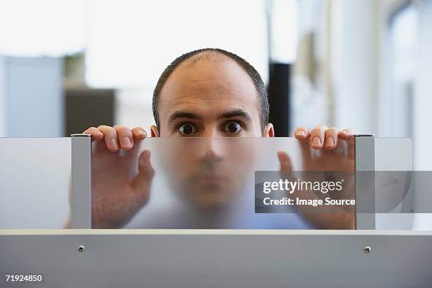 man peering through a glass partition - kalend stockfoto's en -beelden