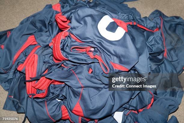 pile of football uniforms - fußballtrikot stock-fotos und bilder