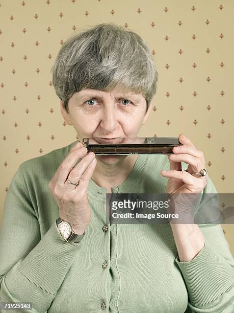 senior woman playing the harmonica - harmonica stock pictures, royalty-free photos & images
