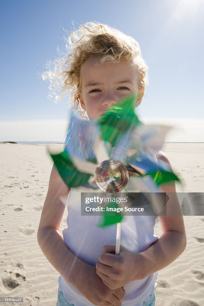 Girl holding pinwheel on beach