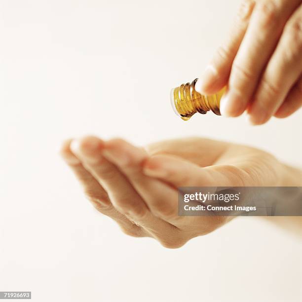 woman pouring essential oil - aromatherapy oil stockfoto's en -beelden