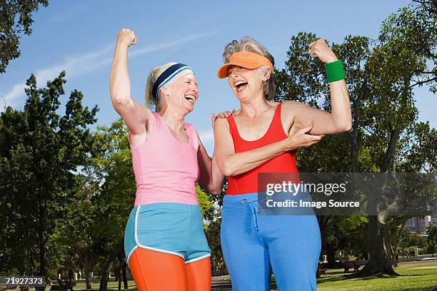 two senior adult women exercising in park - old woman running stock pictures, royalty-free photos & images