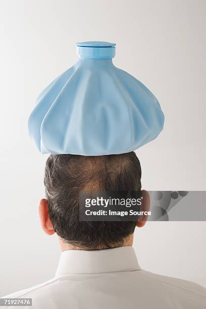 man with ice pack on his head - ijszak stockfoto's en -beelden