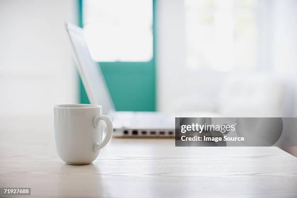 coffee cup and laptop computer - coffee cups table stockfoto's en -beelden