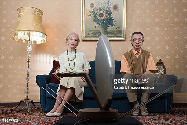 senior couple watching television - malumore foto e immagini stock