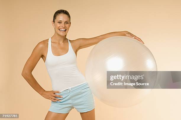 woman holding exercise ball - pilates ball man stock-fotos und bilder