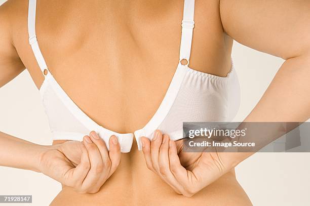 woman fastening her bra - bras pull bildbanksfoton och bilder