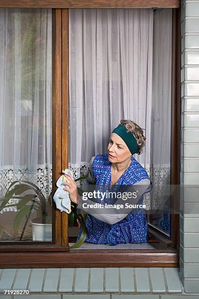 woman dusting window frames - nosy woman stock pictures, royalty-free photos & images