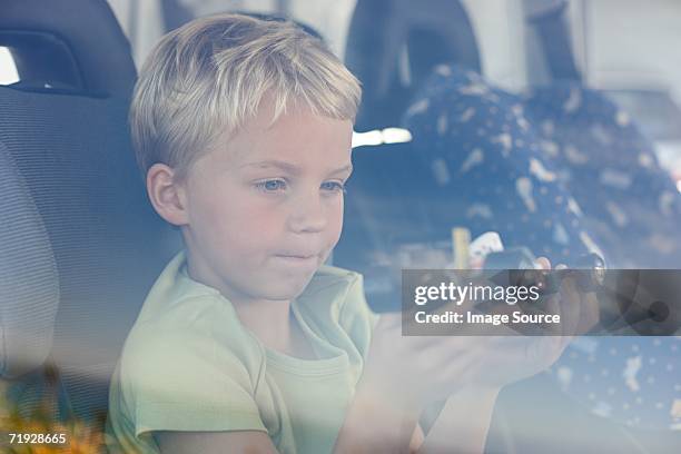 boy sat in car holding toy car - boy playing with cars stock pictures, royalty-free photos & images